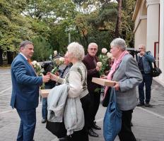Kovács Péter polgármester és Szatmáry László képviselő rózsákat ajándékoz a kerületi idősek napi rendezvényen