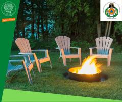 Négy szék a zöldben egy kerti grill körül, amiben ég a tűz.