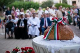 az újkenyér, háttérben az ünneplő érdeklődők