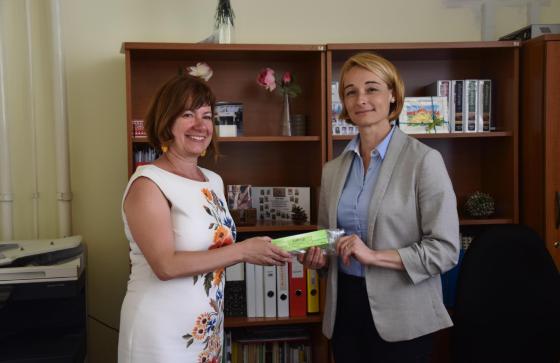 Ács Anikó alpolgármesterasszony átad egy EpiPen-t az Arany János Általános Iskola igazgatójának