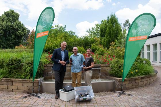 Szász József alpolgármester átadja az összegyűjtött mobileszközöket a Jane Goodall Intézet önkénteseinek.