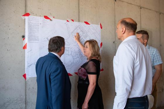 a jelenlevők nézegetik a tervrajzokat