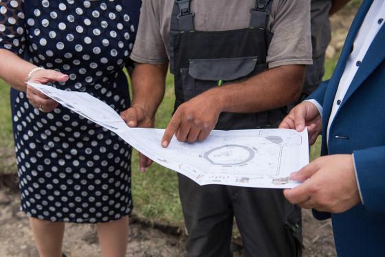 Kovács Péter polgármester, Zánkai Gabika és a kivitelező nézi a játszótér tervrajzát.