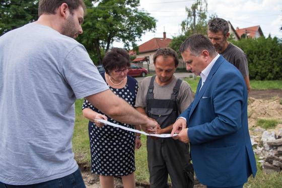 Kovács Péter polgármester, Zánkai Gabika, az önkormányzat alkalmazottja és a kivitelező nézi a játszótér tervrajzát.