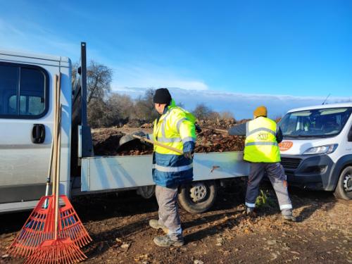 A Kerület Gazda munkatársai teherautóra lapátolják az összegyűjtött falevelet és nyesedéket.