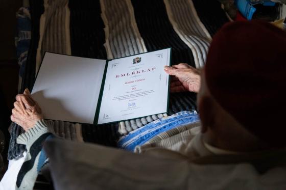 Vili bácsi kezében tartja az emléklapot