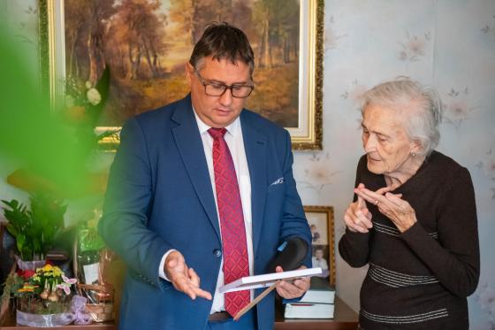 Emmike néni mutatja a családi fotókat Kovács Péter polgármesternek.