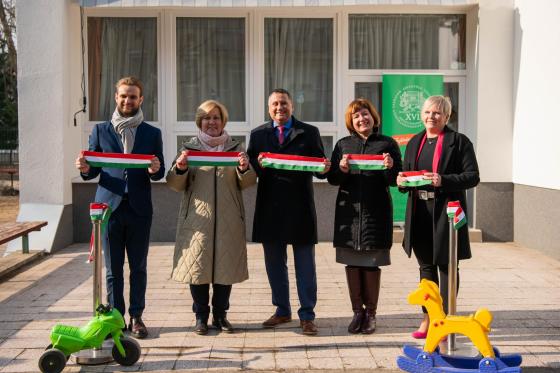 Dénes Hilda intézményvezető, Kovács Péter polgármester, Ács Anikó alpolgármester, Simon Mariann önkormányzati kapcsolattartó és a kivitelező képviselője a nemzeti színű szalaggal a kezükben a Gyerekkuckó Óvoda átadóján.