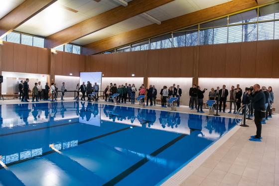 Életkép a felújított Szentmihályi Konrád Ferenc Uszoda uszodateréről, ahogyan az ünneplők körbejárják.