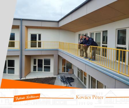 Kovács Péter polgármester, Mikulás Franciska intézményvezető és az építésvezető a teraszról figyelik az építkezést