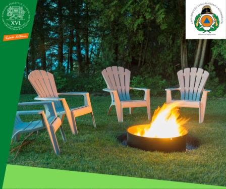 Négy szék a zöldben egy kerti grill körül, amiben ég a tűz.