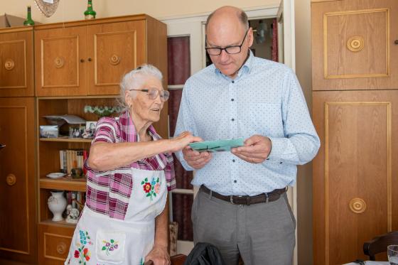 Szabó Imréné a családi albumot mutatja Szász József alpolgármesternek.