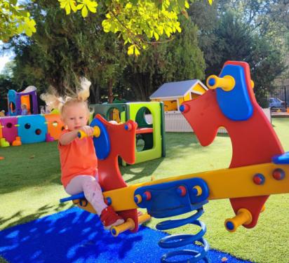 Gyerekek játszanak a Szivárvány Bölcsőde megújult udvarán az új játékokkal