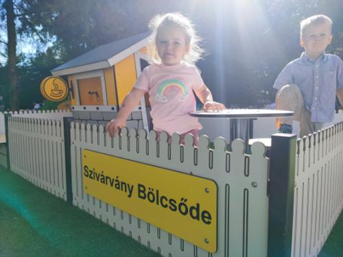 Gyerekek játszanak a Szivárvány Bölcsőde megújult udvarán az új játékokkal